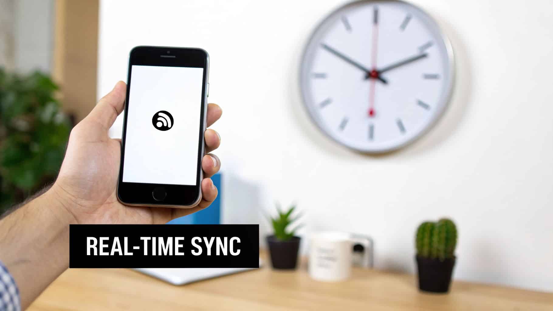 A hand holds a smartphone displaying a sync logo, with 'REAL-TIME SYNC' text.